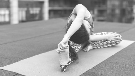 young woman stretching on yoga mat