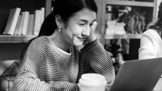 Young woman at a coffee shop with a laptop